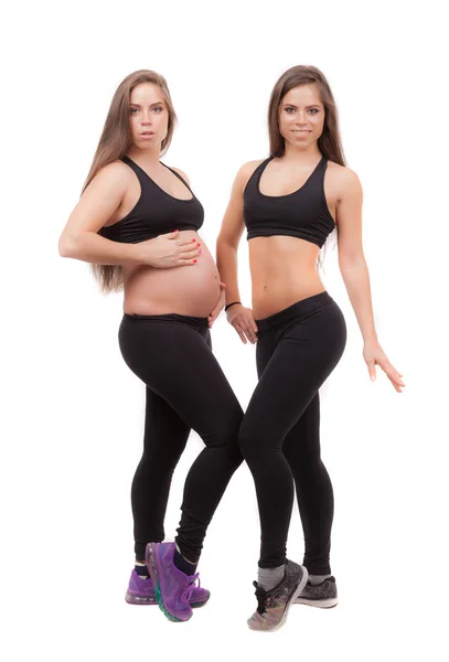 白い背景に彼女の双子の妹で妊娠中の女性. — ストック写真