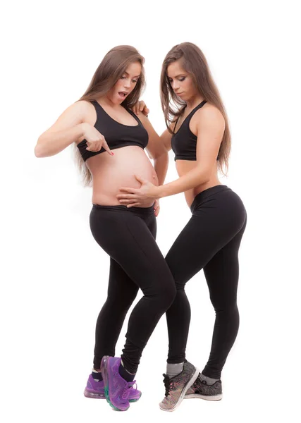 Femme enceinte avec sa sœur jumelle sur fond blanc . — Photo