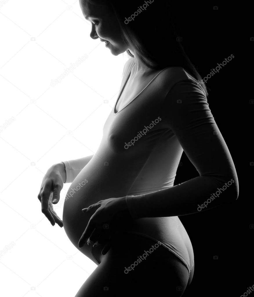 Pregnant woman in a white bodysuit on a white and black background.