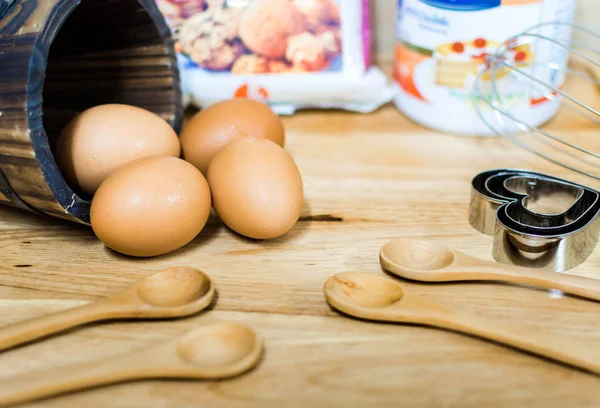 Mehl mit Ei und Zutaten für hausgemachte Backwaren auf Holzgrund — Stockfoto