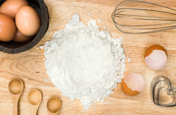 Üstten Görünüm kompozisyon un yumurta ve ahşap zemin üzerine ev yapımı ekmek için malzemeler