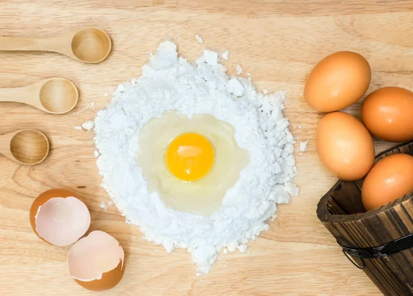 Zusammensetzung Mehl mit Ei und Zutaten für hausgemachte Backwaren auf Holzgrund — Stockfoto