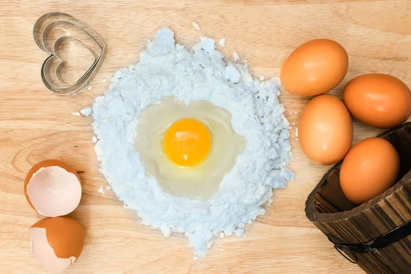 Üstten Görünüm kompozisyon un yumurta ve ahşap zemin üzerine ev yapımı ekmek için malzemeler