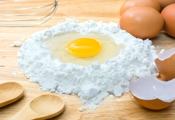 Mąka z jajkiem i składniki na domowe wypieki na podłoże drewniane — Zdjęcie stockowe