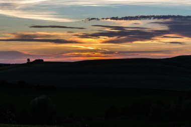 Arka planda bir ev ile güzel bir gün batımı