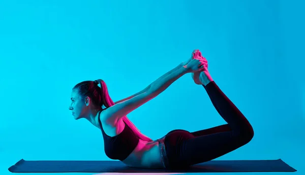 Woman yoga exercices dhanurasana bow pose — Stockfoto