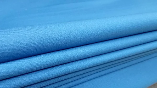 Nya industriella blå rulle, blå bakgrund. Koncept: material, tyg, tillverkning, plagg fabrik, nya prover av tyger. — Stockfoto