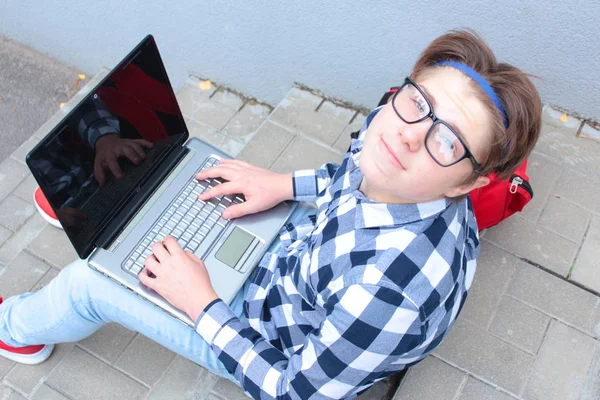 男子生徒または学生 はティーンエイ ジャーが階段に座って シャツ 笑みを浮かべて 赤いランドセルを背負って コンピューターでの作業 — ストック写真