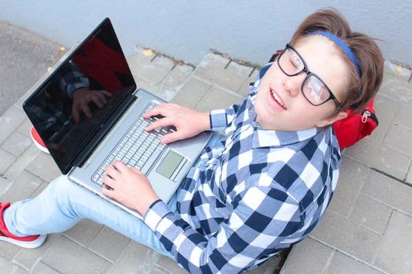 男子生徒または学生 はティーンエイ ジャーが階段に座って シャツ 笑みを浮かべて 赤いランドセルを背負って コンピューターでの作業 — ストック写真