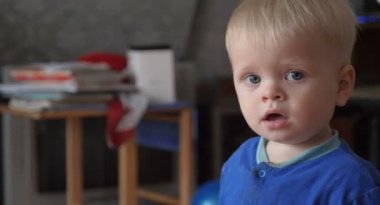 Küçük bir güzel bebek görünüyor kamera, güzel mavi gözlü, sarı saçlı.