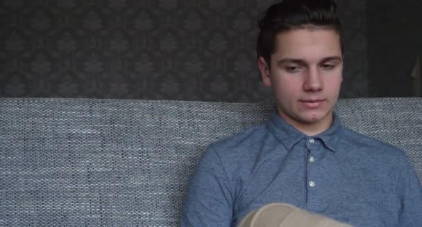 Schöner Junge Teenager Telefoniert Sitzt Auf Einem Grauen Sofa Brünett — Stockvideo