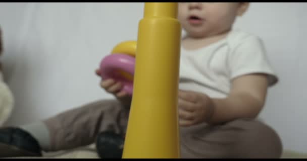 小さな赤ちゃん 男の子 再生グッズ ピラミッド 白い背景を座っています コンセプト 赤ちゃん 公正な皮膚 美しい子供 — ストック動画