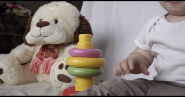 Küçük bebek (çocuk), oynamak oyuncak Piramit, beyaz arka plan oturur. Konsept: bebekler, Cilt, güzel çocuk Fuarı.