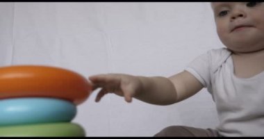 Güzel küçük bir çocuk (çocuk), portresi oyun oyuncak Piramit, sarışın, ışık saçlı, mavi gözlü, beyaz arka plan oturur. Konsept: bebekler, Cilt, güzel çocuk Fuarı.