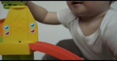 Güzel küçük yürümeye başlayan çocuk (çocuk), portresi oyun oyuncak arabalar, sarışın, ışık saçlı, mavi gözlü, beyaz arka plan oturur. Konsept: bebekler, Cilt, güzel çocuk Fuarı.