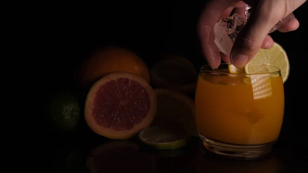 ガラス 柑橘系の果物 黒の背景のオレンジ ジュース — ストック写真