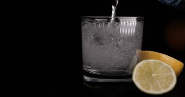 Limon, limon ile maden suyu (baloncuklar) cam, siyah arka plan.