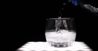 Limon, limon ile maden suyu (baloncuklar) cam, siyah arka plan.