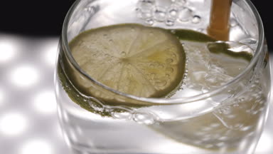 Limon, limon ile maden suyu (baloncuklar) cam, siyah arka plan.