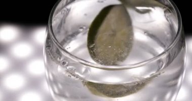 Limon, limon ile maden suyu (baloncuklar) cam, siyah arka plan.