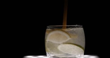 Limon, limon ile maden suyu (baloncuklar) cam, siyah arka plan.