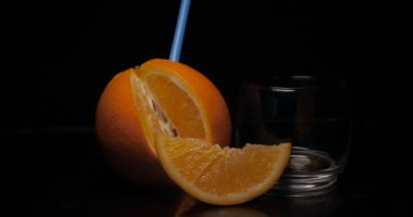 Cam, siyah arka planda portakal suyu.