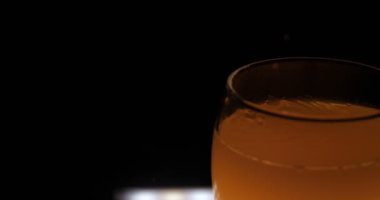 Cam, siyah arka planda portakal suyu.