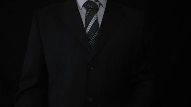Takım elbise, siyah arka planda işadamı.