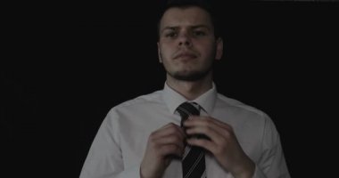 Yakışıklı genç iş adamı beyaz gömlek, siyah arka plan.