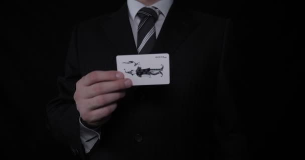 Businessman Magician Holds Playing Card Joker Suit Black Background — Stock Video