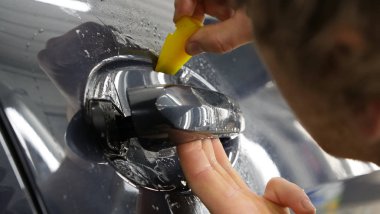 Ön far ve kaputta Ppf montaj işlemine yakın. Ppf, boyayı çizilmelerden ve taş yongalarından koruyan bir Boya Koruma Filmidir. Konsept: Koruma, Koruma, Araba, Yeni, İş.