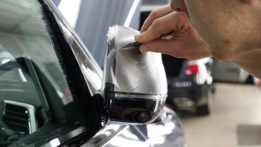 Ön far ve kaputta Ppf montaj işlemine yakın. Ppf, boyayı çizilmelerden ve taş yongalarından koruyan bir Boya Koruma Filmidir. Konsept: Koruma, Koruma, Araba, Yeni, İş.