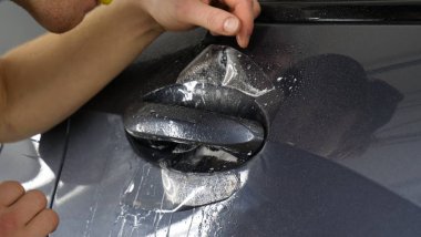 Ön far ve kaputta Ppf montaj işlemine yakın. Ppf, boyayı çizilmelerden ve taş yongalarından koruyan bir Boya Koruma Filmidir. Konsept: Koruma, Koruma, Araba, Yeni, İş.
