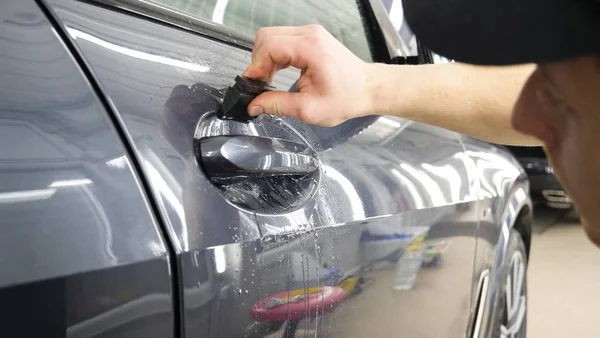 Ön far ve kaputta Ppf montaj işlemine yakın. Ppf, boyayı çizilmelerden ve taş yongalarından koruyan bir Boya Koruma Filmidir. Konsept: Koruma, Koruma, Araba, Yeni, İş.