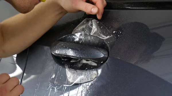 Ön far ve kaputta Ppf montaj işlemine yakın. Ppf, boyayı çizilmelerden ve taş yongalarından koruyan bir Boya Koruma Filmidir. Konsept: Koruma, Koruma, Araba, Yeni, İş.