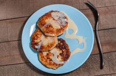 İştah açıcı ekşi krema bir tahta üzerinde mavi bir plaka üzerinde krema ile