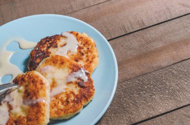 İştah açıcı ekşi krema bir tahta üzerinde mavi bir plaka üzerinde krema ile