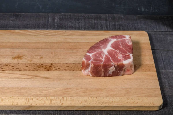 Ahşap bir tahta üzerinde çiğ et parçası 