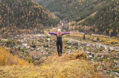 Bir kız leylak ceket kollarında bir dağ, bir görünümü bir sonbahar orman ve dağlar bir bulutlu gün tarafından germe boş alan metin için
