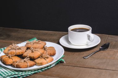 Yeşil bir peçete ve ev yapımı kurabiye beyaz bir fincan sade kahve.