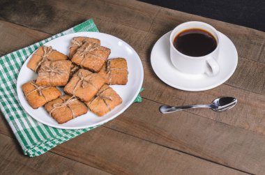 Yeşil bir peçete ve ev yapımı kurabiye beyaz bir fincan sade kahve.