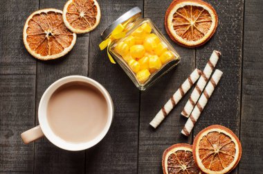 Sıcak çikolata, tarçın çubukları, portakal ve şeker bir koyu ahşap arka plan üzerinde görünümü top