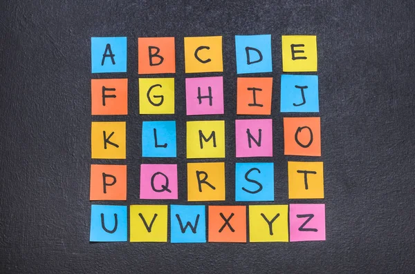 English alphabet on bright colored stickers close up