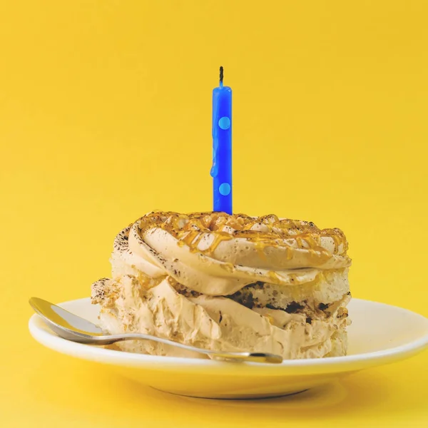 クリーム色と黄色の背景上の単一の蝋燭とチョコレート ケーキ — ストック写真
