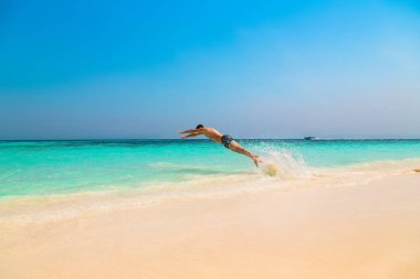 Mutlu genç adam okyanus içine atlama