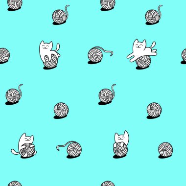 beyaz kedi yün topları ile oynuyor.