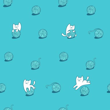 beyaz kedi yün topları ile oynuyor.