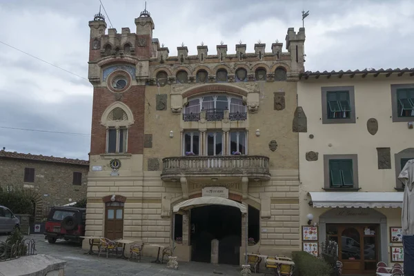 MONTECATINI ALTO, ITALY - февраль 2018 средневековое здание с балконом и широкими воротами на центральной городской площади в окружении уличного кафе и небольших магазинов — стоковое фото