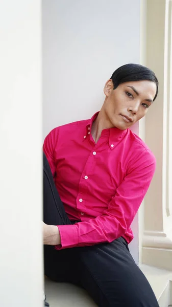 portrait of attractive man in red shirt posing while walking in central mall of Moscow