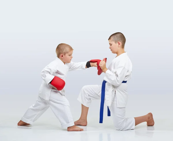 En el simulador pequeño karateka chico está entrenando brazo de ponche — Foto de Stock